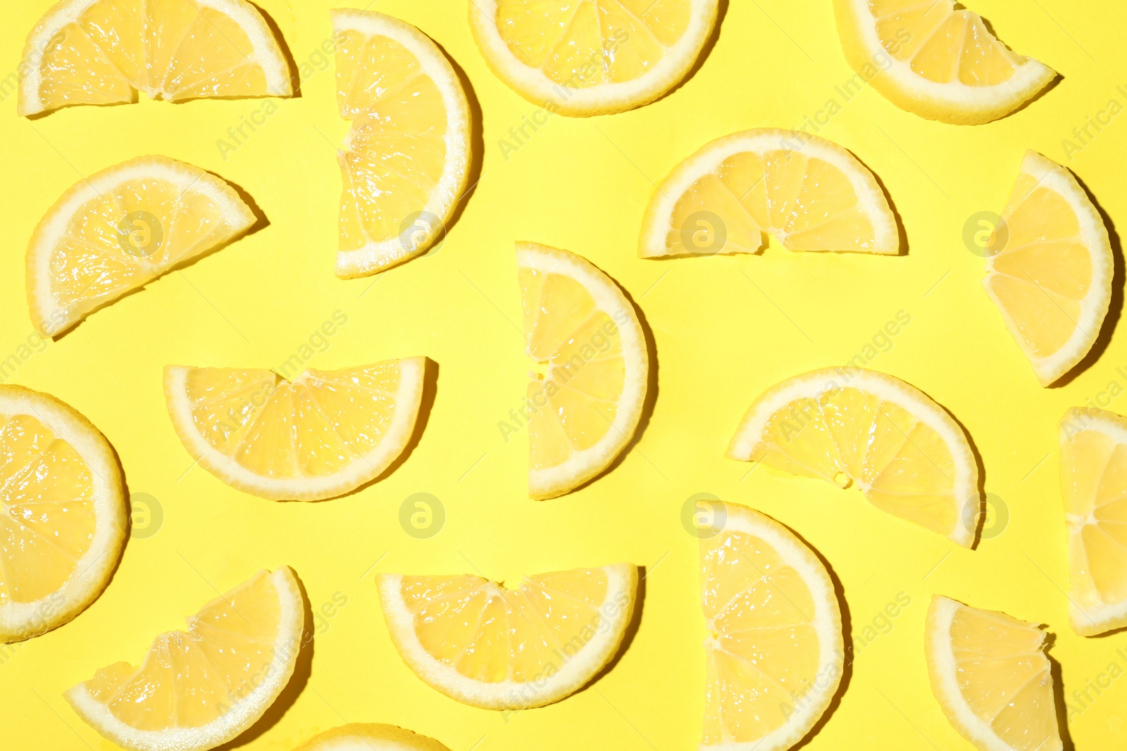 Photo of Juicy lemon slices on yellow background, flat lay