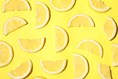 Juicy lemon slices on yellow background, flat lay