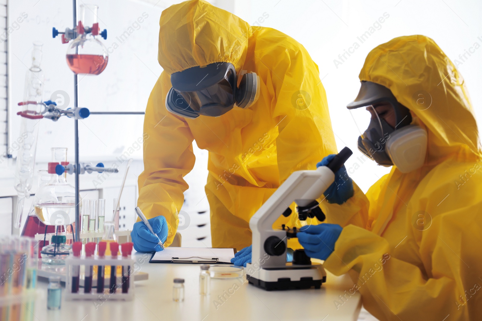 Photo of Scientists in chemical protective suits working at laboratory. Virus research