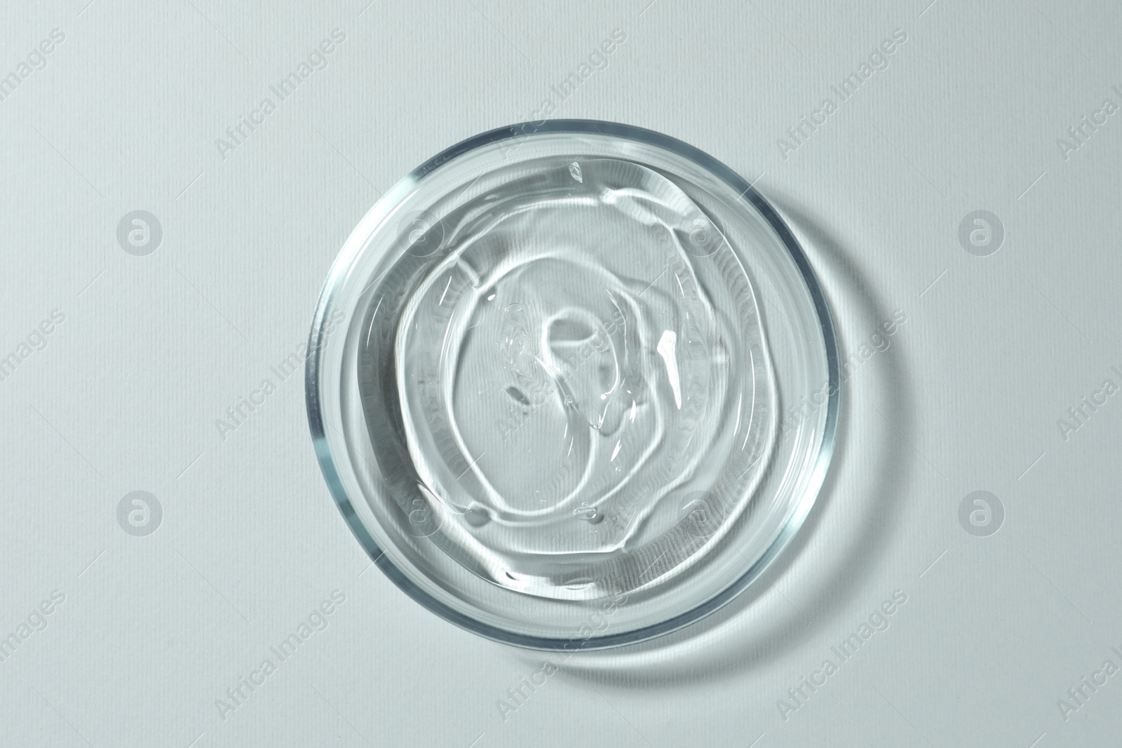 Photo of Petri dish with liquid on white background, top view