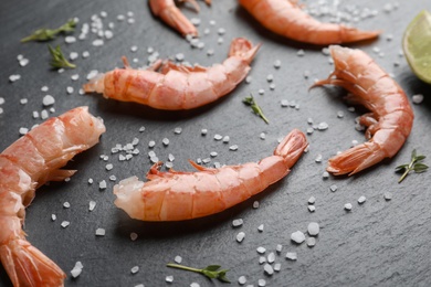 Photo of Fresh shrimps with lime and salt on dark background