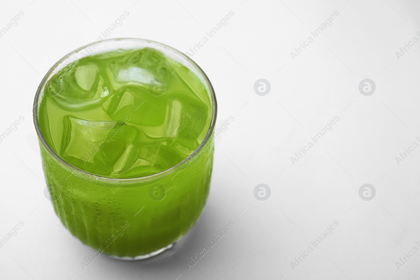 Photo of Glass of delicious iced green matcha tea on white background, closeup. Space for text