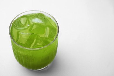 Glass of delicious iced green matcha tea on white background, closeup. Space for text