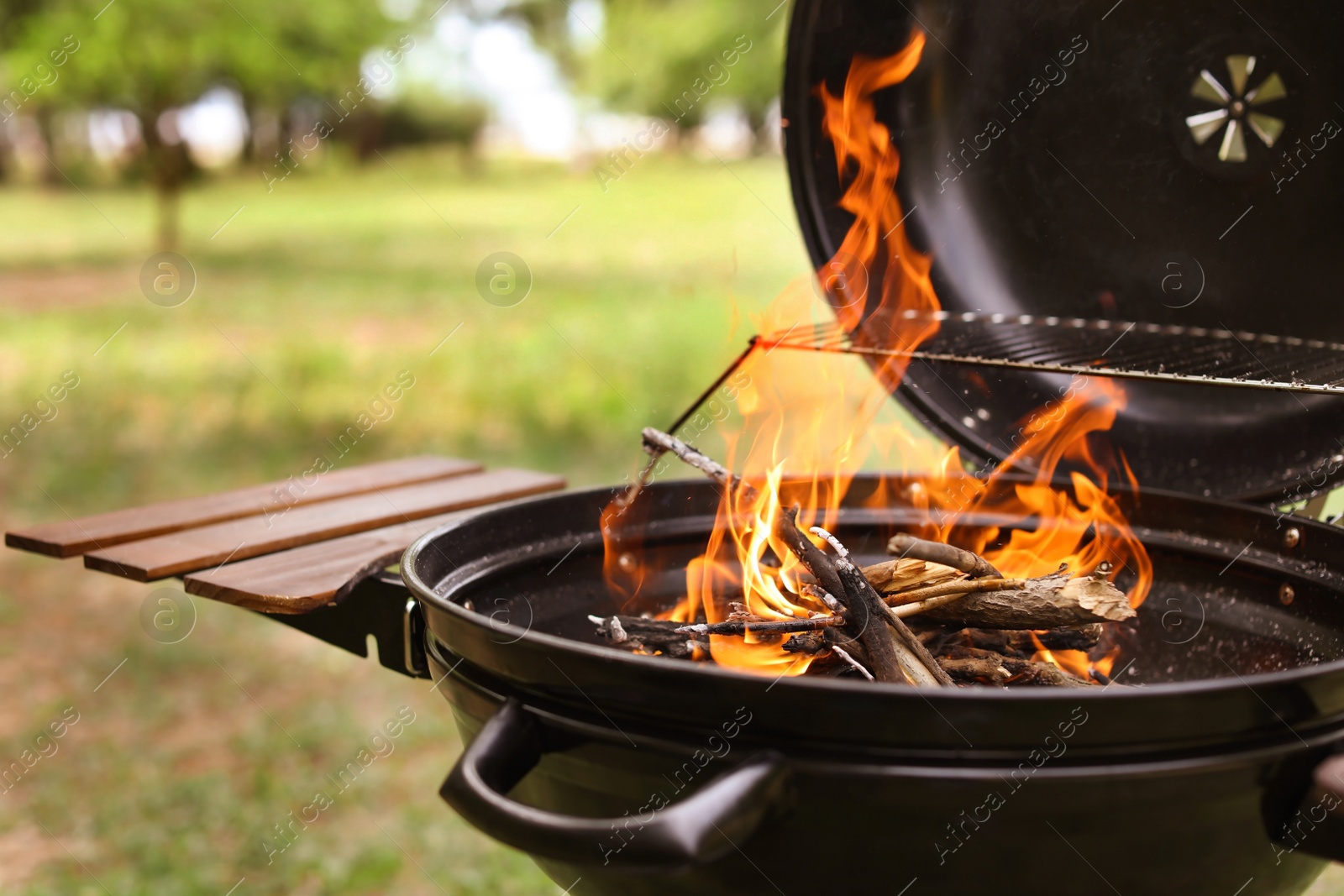 Photo of Modern barbecue grill with fire flames outdoors