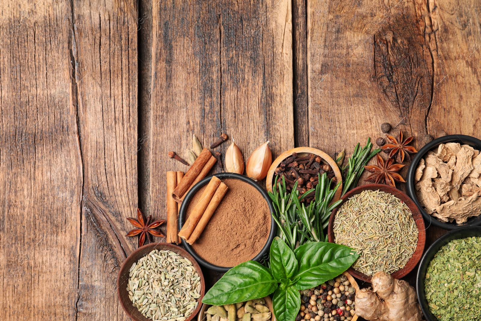 Photo of Flat lay composition with different natural spices and herbs on wooden table, space for text