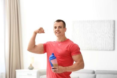 Athletic young man with protein shake at home