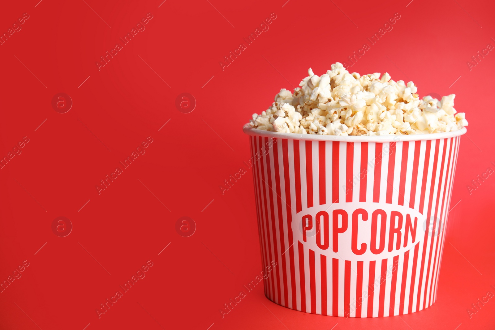 Photo of Tasty pop corn on red background. Space for text