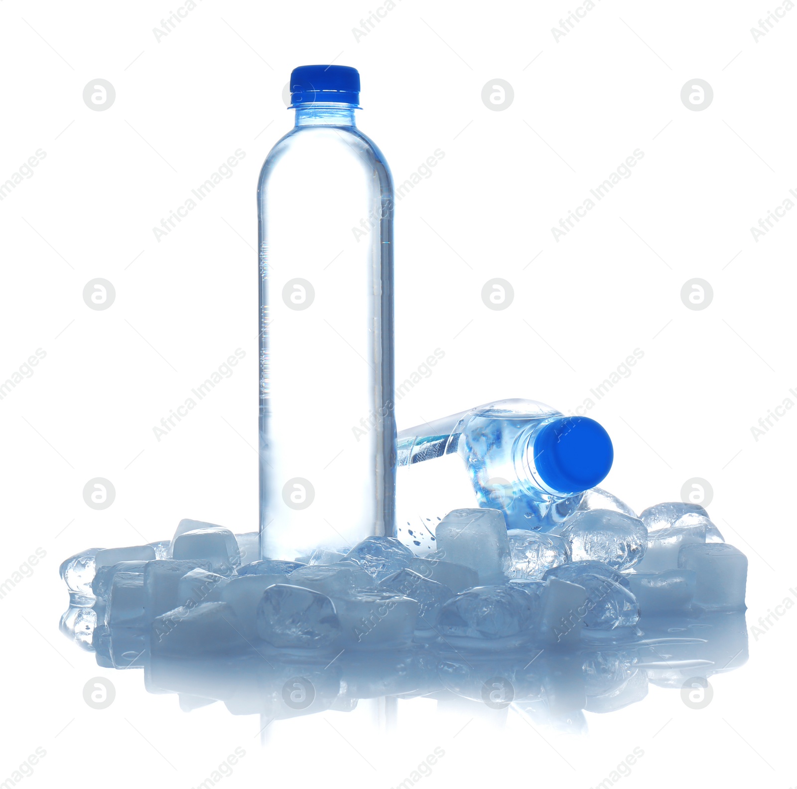 Photo of Bottles of water and ice cubes on white background