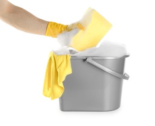 Photo of Man holding sponge over bucket with foam on white background, closeup. Cleaning supplies