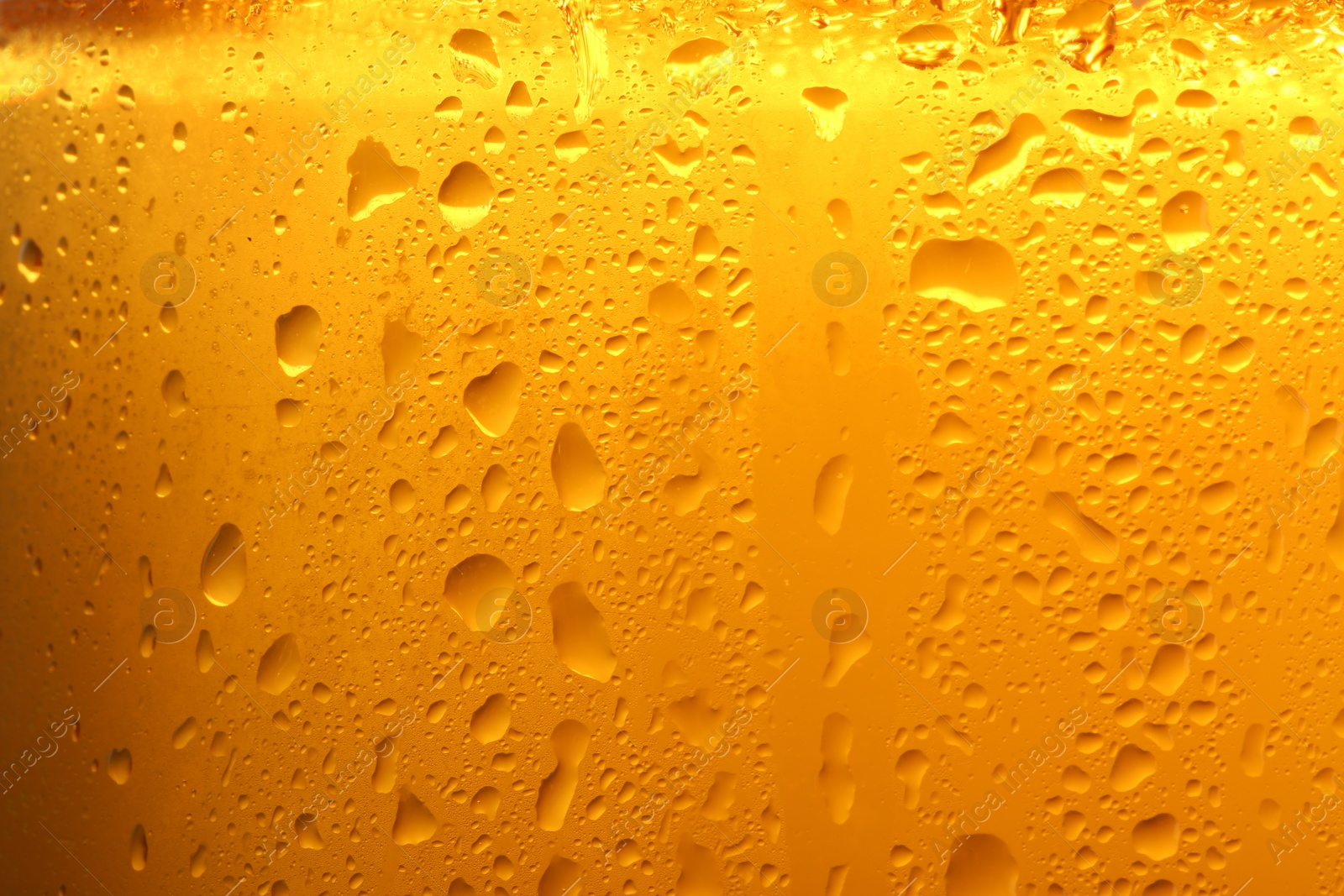 Photo of Glass of tasty cold beer with condensation drops as background, closeup