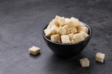 Photo of Crispy rusks in bowl on grey table