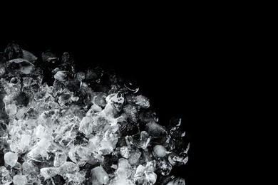 Heap of crushed ice on black table, top view. Space for text