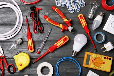 Flat lay composition with electrician's tools on wooden background