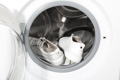 Stylish clean sneakers inside modern washing machine