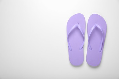 Photo of Stylish violet flip flops on white background, top view. Space for text