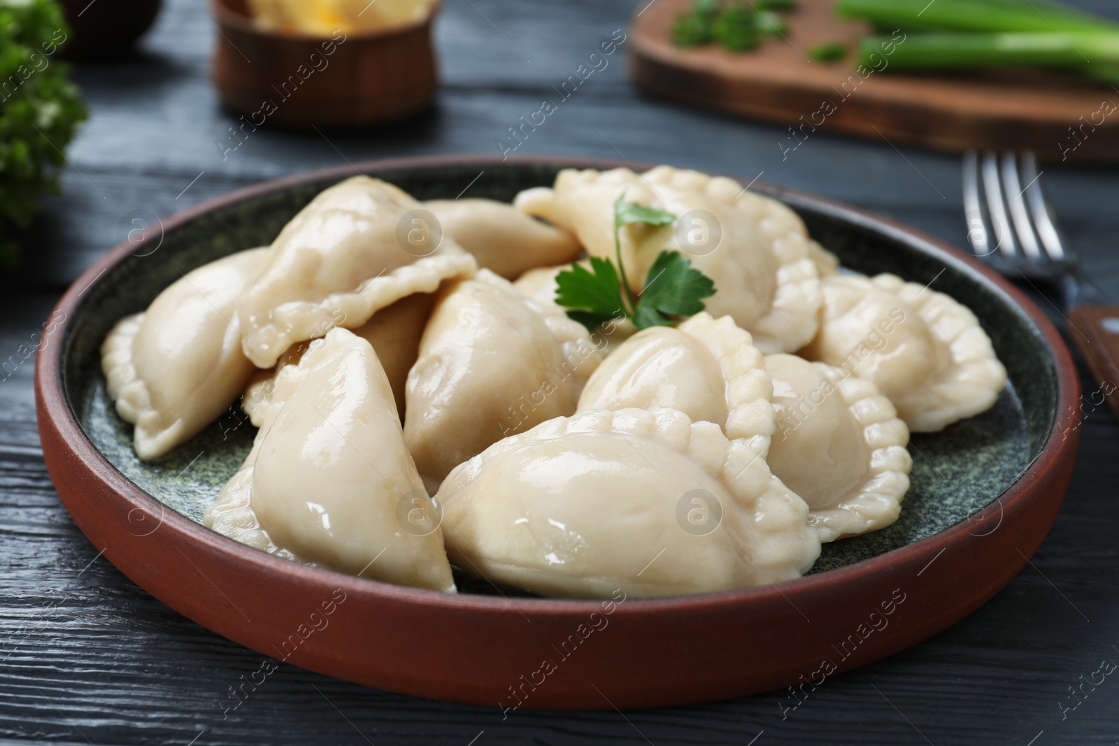 Photo of Plate of tasty dumplings served with parsley on table
