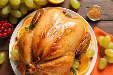 Photo of Platter of cooked turkey with garnish on table, top view