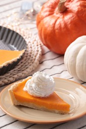 Photo of Piece of fresh homemade pumpkin pie with whipped cream on table