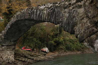 Photo of Adjara, Georgia - November 19, 2022: Picturesque view of stone arched bridge over Acharistskali river in mountains