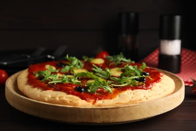 Photo of Pita pizza with cheese, olives and arugula on wooden table, closeup