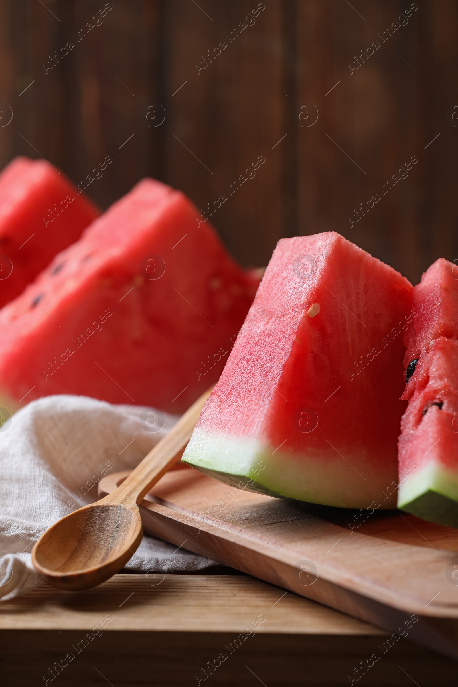 Photo of Sliced fresh juicy watermelon on wooden table, closeup. Space for text
