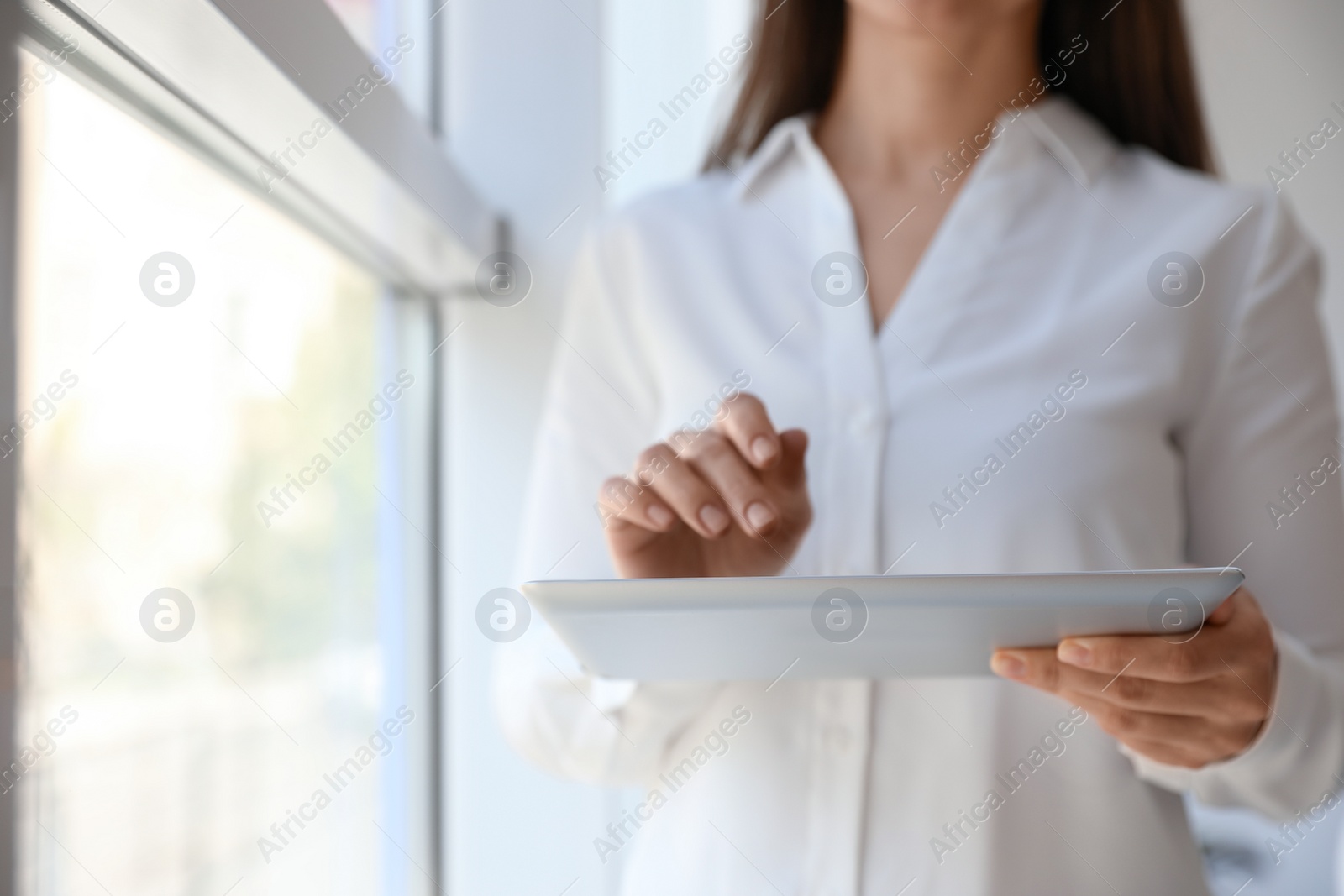 Photo of Businesswoman working with modern tablet in office, closeup