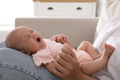 Mother with her cute sleepy baby at home, closeup