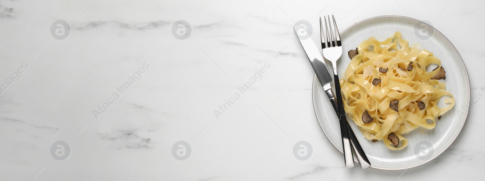 Image of Delicious pasta with truffle slices on white table, top view with space for text. Banner design