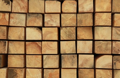 Photo of Many stacked wooden beams as background, closeup