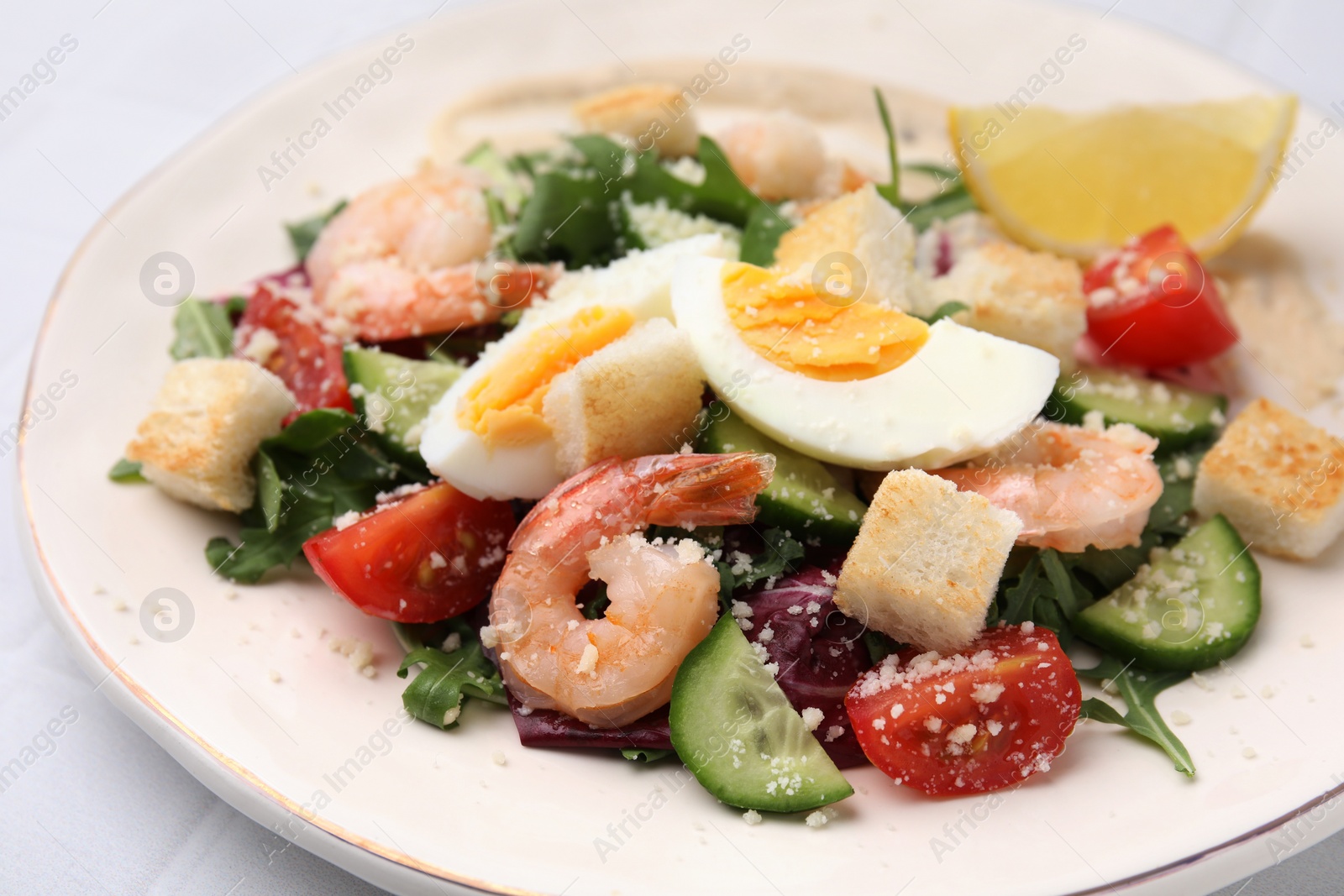 Photo of Delicious Caesar salad with shrimps on white table, closeup