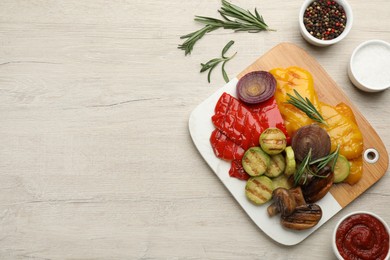 Photo of Delicious grilled vegetables served on white wooden table, flat lay. Space for text