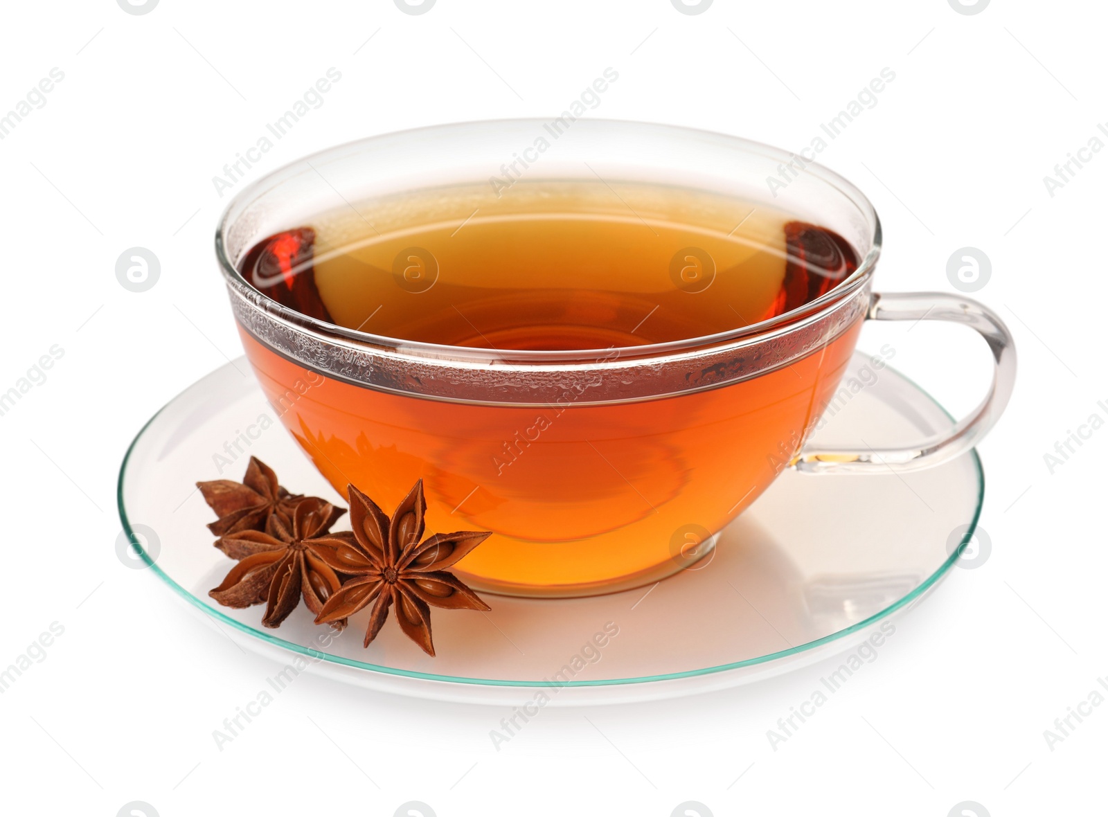 Photo of Glass cup of hot tea with anise stars on white background