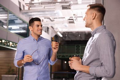 Coworkers talking during coffee break in office