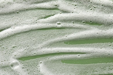 Photo of White washing foam on olive background, top view