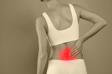Image of Woman suffering from back pain on color background, closeup