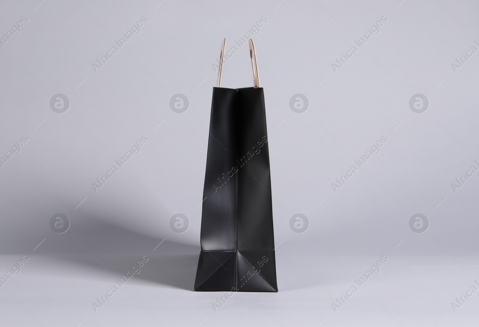 Photo of One black paper shopping bag on grey background