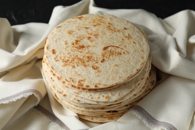 Photo of Stack of tasty homemade tortillas on table