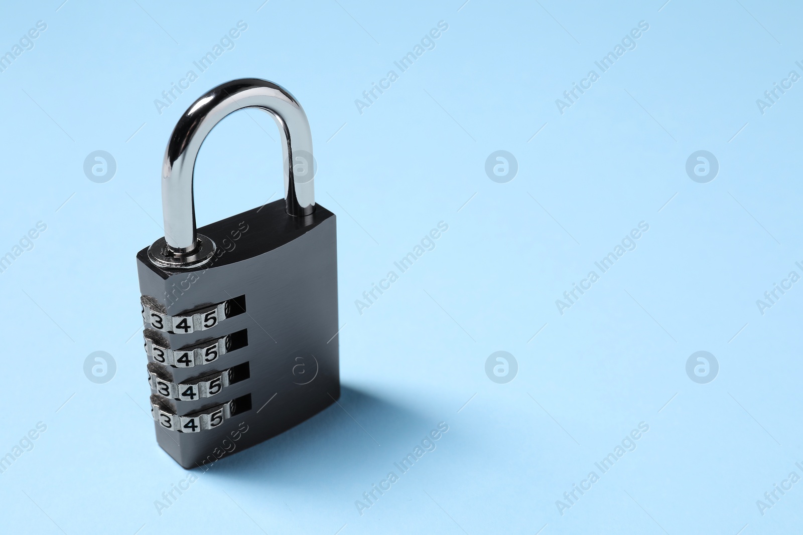 Photo of Steel combination padlock on light blue background. Space for text