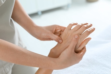 Photo of Woman receiving hand massage in wellness center, closeup