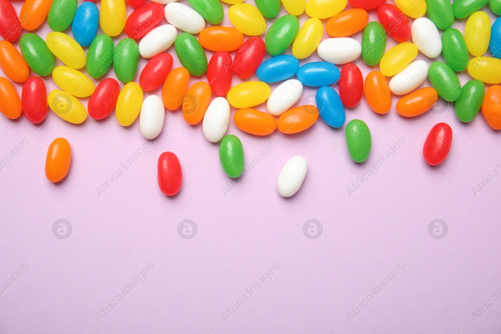 Photo of Flat lay composition with jelly beans on color background. Space for text