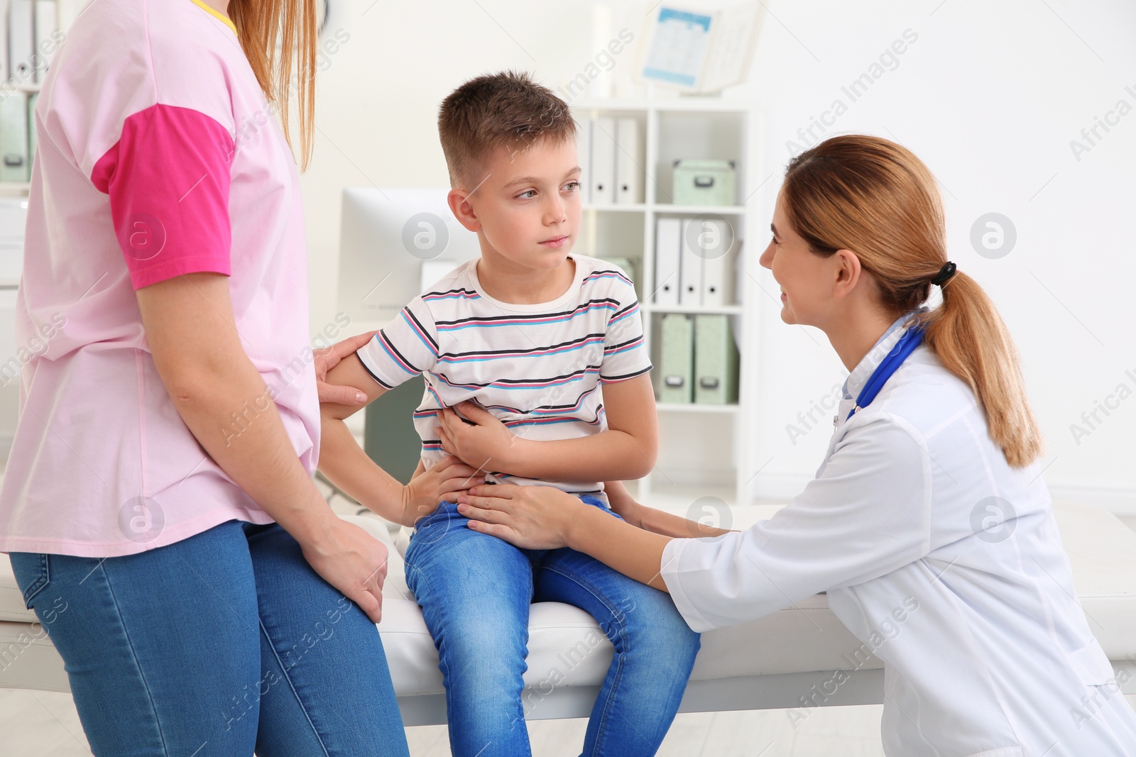 Photo of Mother and son visiting pediatrician. Doctor working with patient in hospital