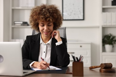 Notary with clipboard writing notes at workplace in office