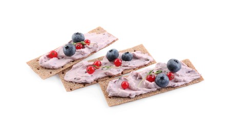Photo of Tasty cracker sandwiches with cream cheese, blueberries, red currants and thyme on white background