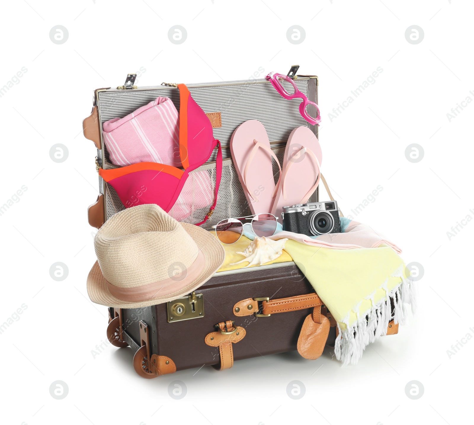 Photo of Open vintage suitcase with different beach objects packed for summer vacation isolated on white