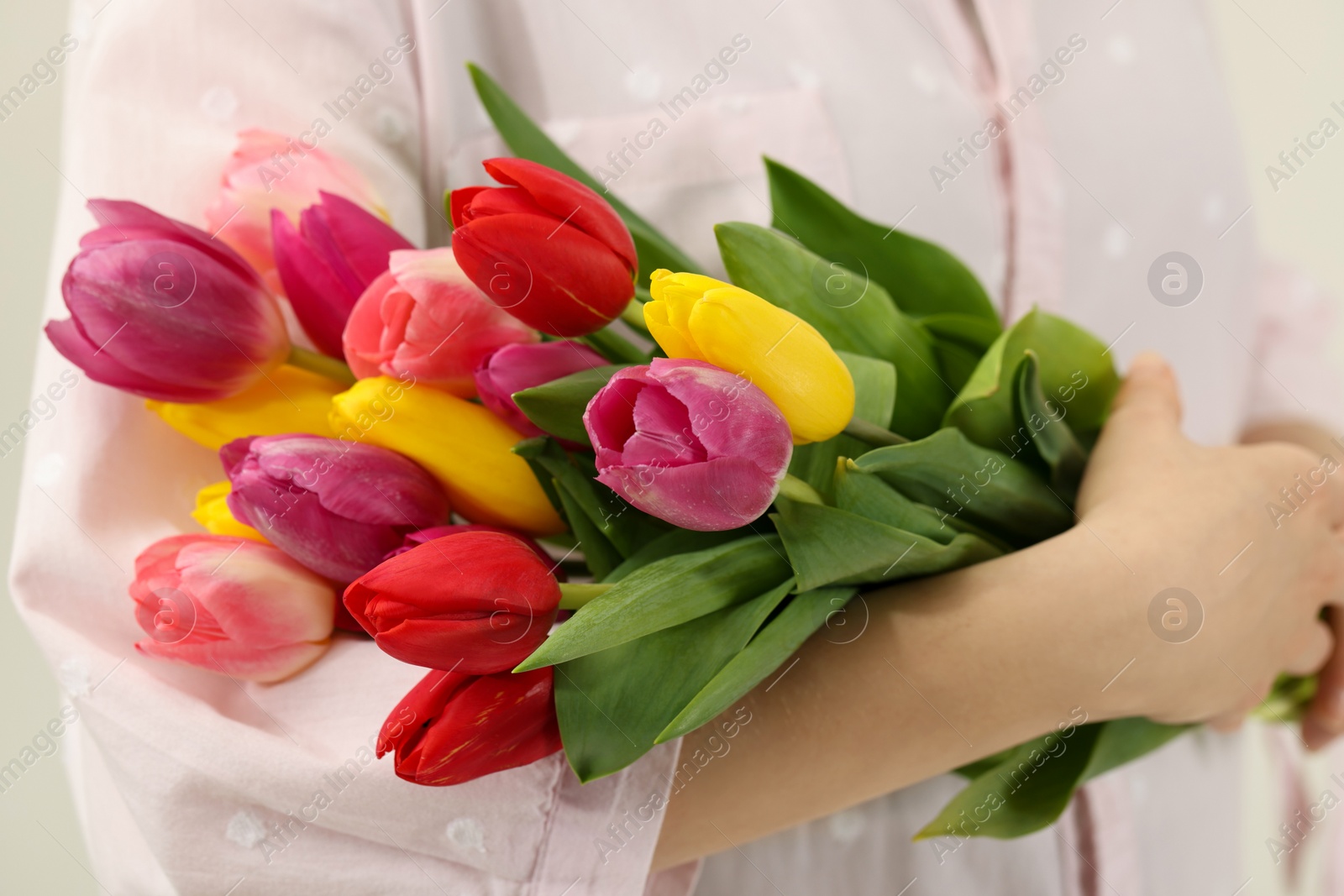 Photo of Woman holding beautiful colorful tulip flowers, closeup