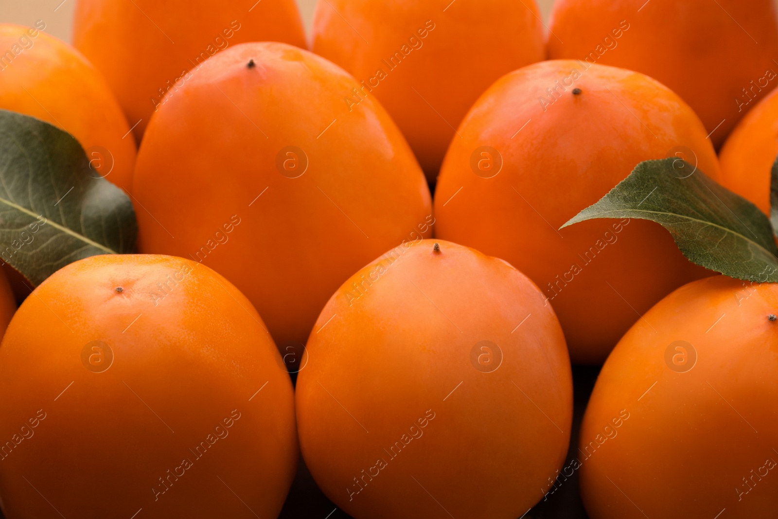 Photo of Pile of delicious ripe juicy persimmons as background, closeup