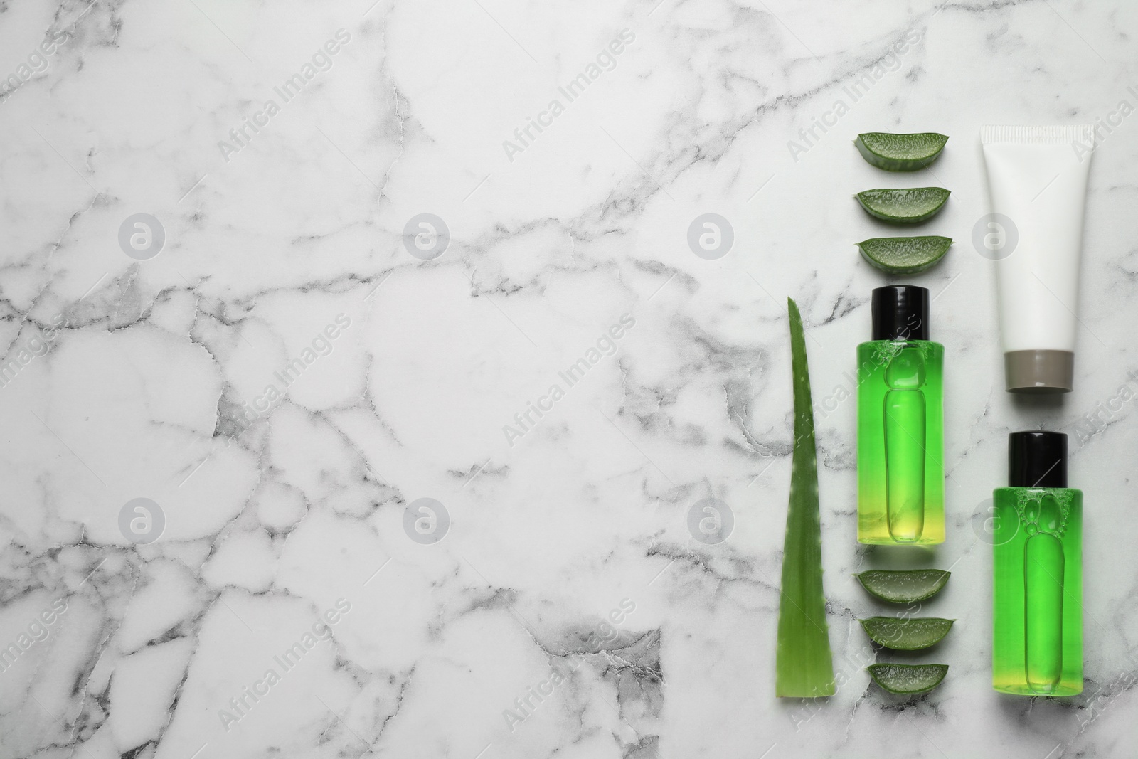 Photo of Flat lay composition with aloe vera and cosmetic products on white marble background. Space for text