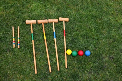 Set of croquet equipment on green grass, flat lay