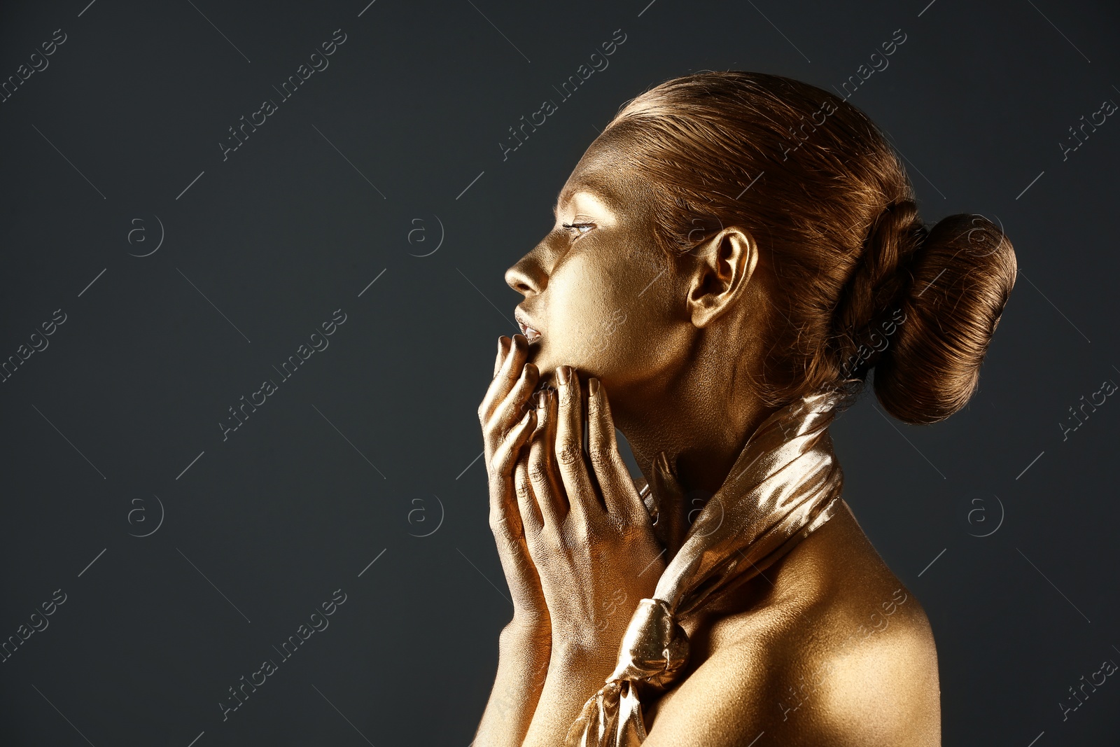 Photo of Portrait of beautiful lady with gold paint on skin against grey background