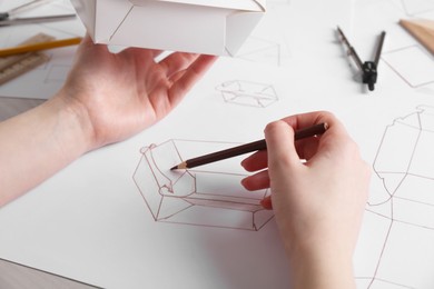 Woman creating packaging design at table, closeup